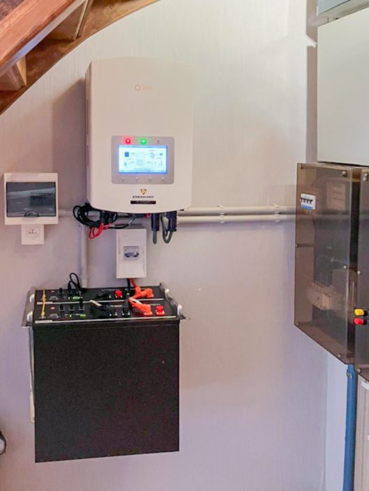 Binnenopstelling met Solis omvormer en zwarte thuisbatterijkast onder trap, netjes geïntegreerd