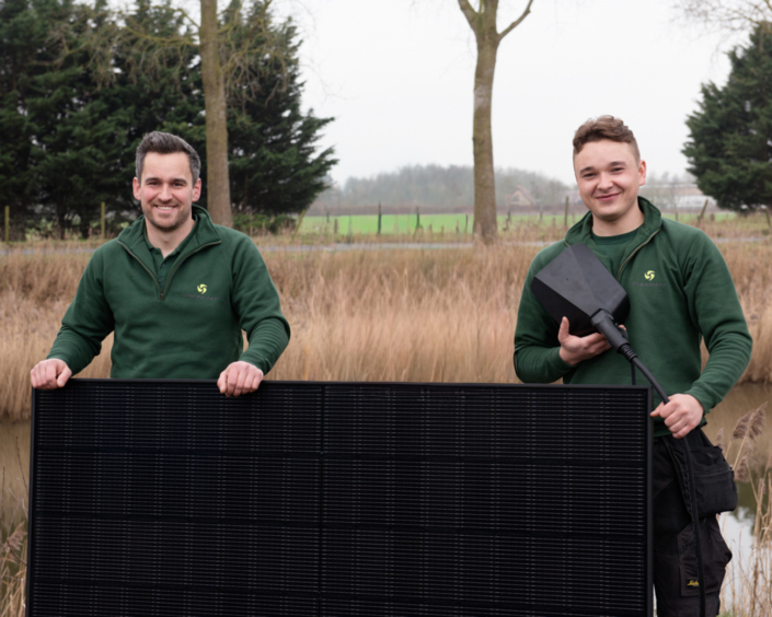 Michiel en Brecht hebben samen één van hun zonnepanelen vast.