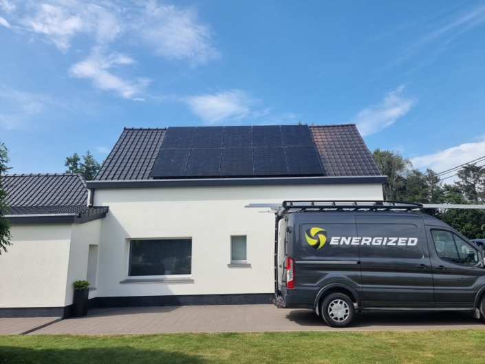 Moderne installatie van zonnepanelen op zwarte dakpannen in Lievegem met Energized servicewagen